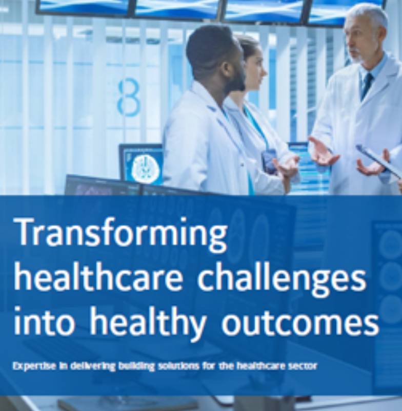 Doctors in discussion in an OR, with the text 'Transforming healthcare challenges into healthy outcomes' overlaid in the middle