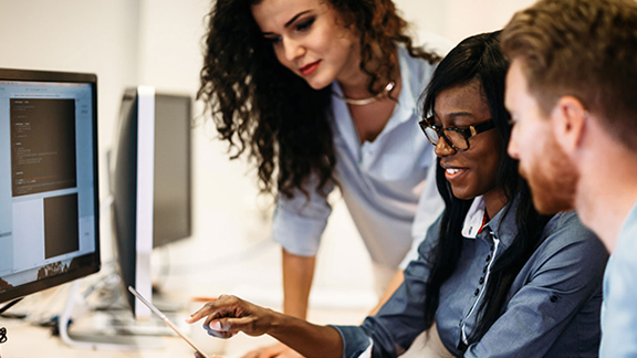 Three Colleagues collaborating on a computer