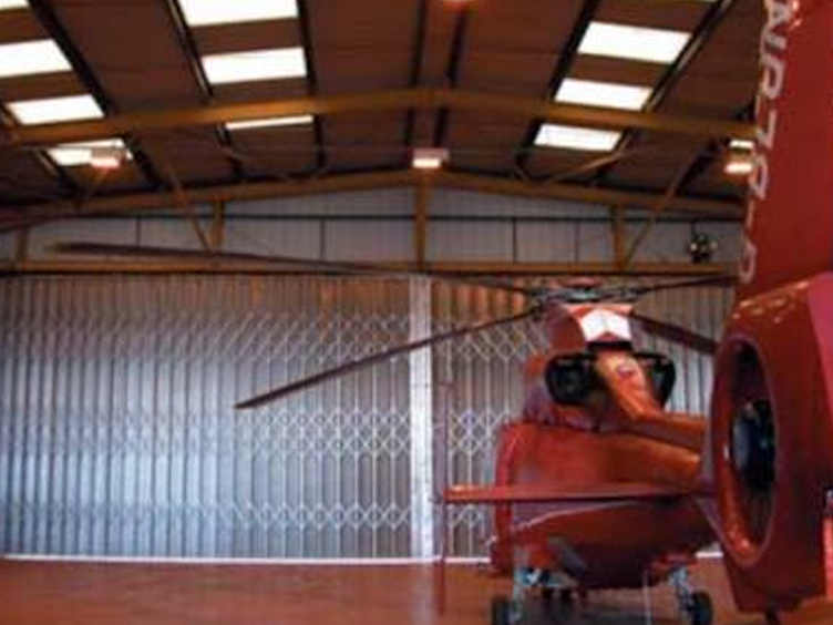 Helicopter kept inside a hangar with folding shutters