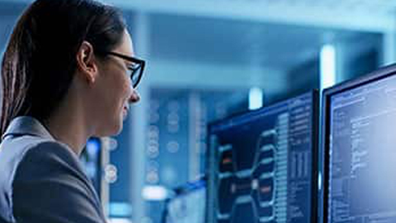 Woman working in front of two computer screens