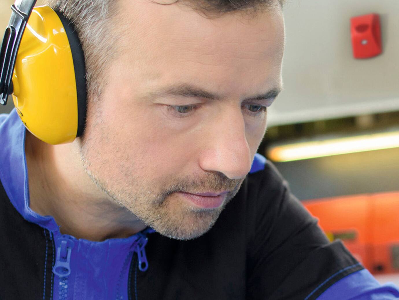 Close-up of a maintenance worker's face wearing safety headphones