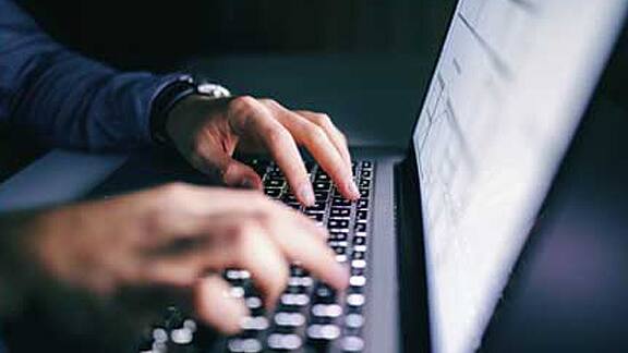 close up of a person working on a laptop