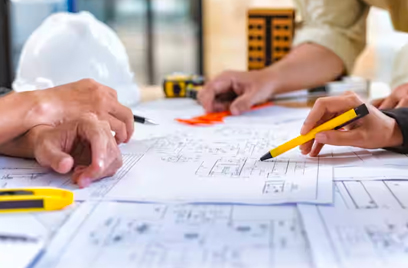 Close-up of people examining blueprints