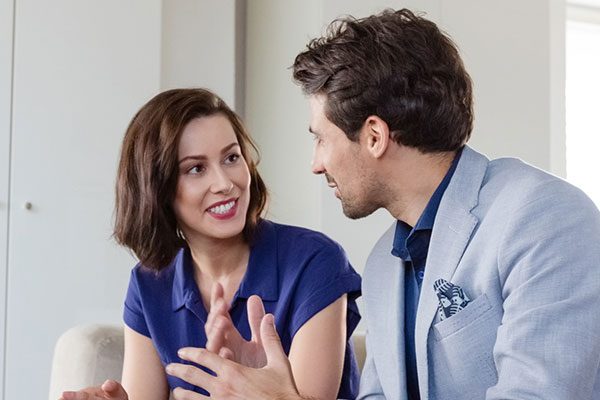 Two people on a couch having a conversation