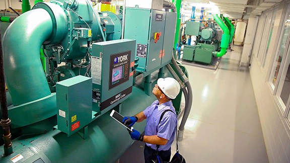 Man with Tablet checking Machine Functions.