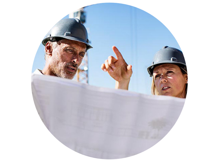 Two engineers in safety helmets analyzing a chart