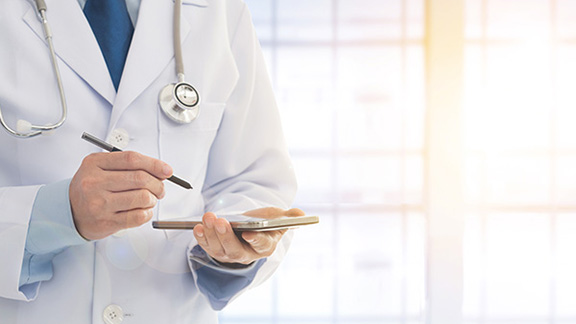 A doctor working on a tablet with a stylus