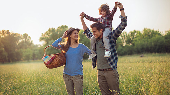 A family out for a picnic in an open green field
