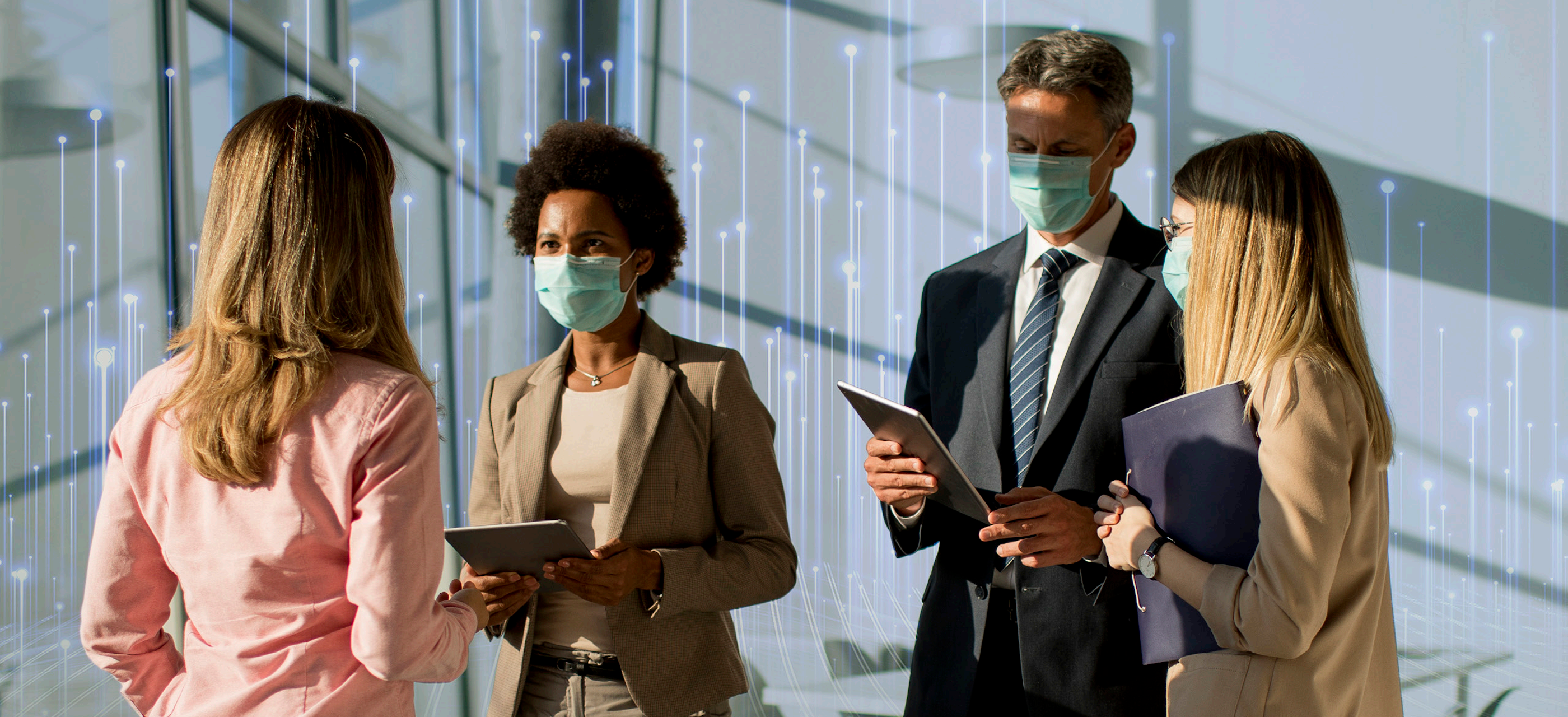 Two business people with tablets talking to two others
