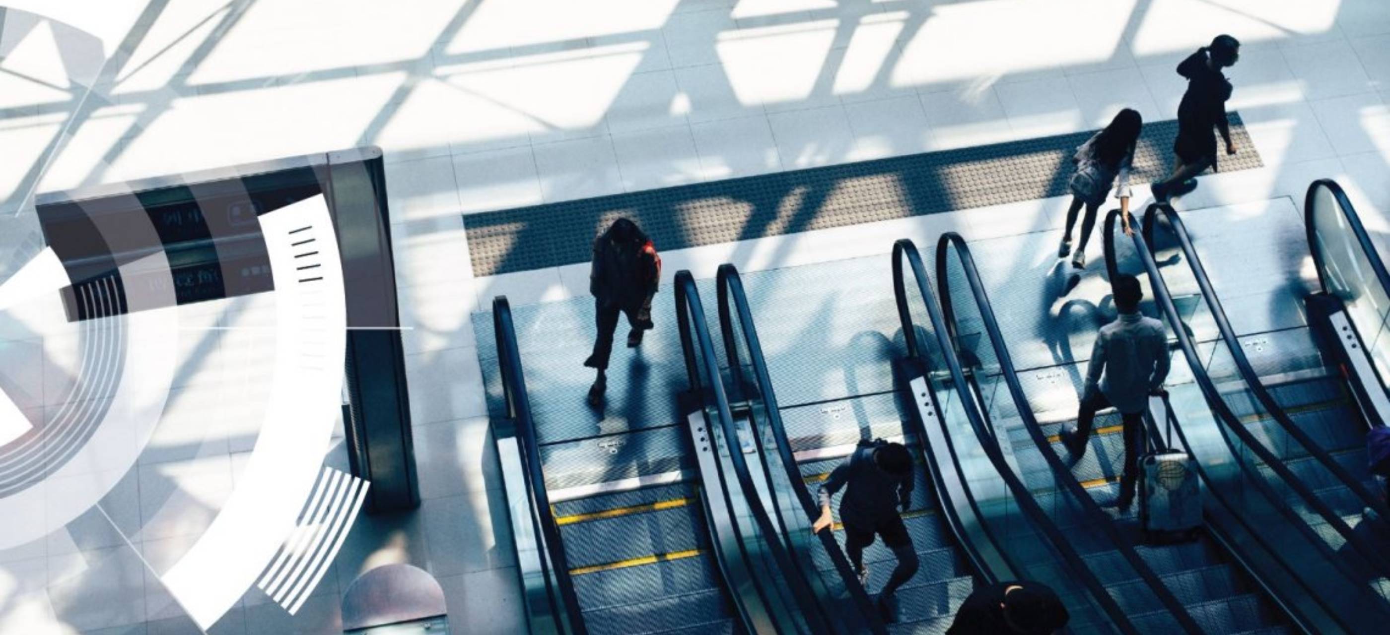 Top-angle view of people using an escalator in a commercial building