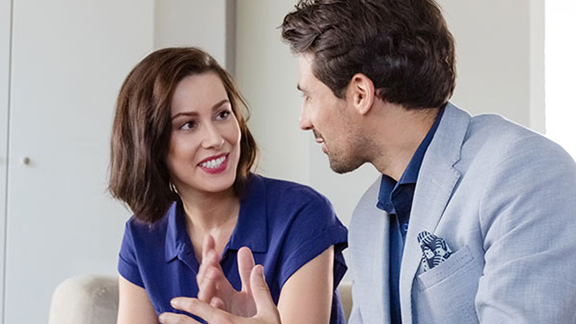 Two people on a couch having a conversation