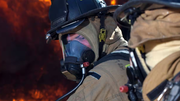 Two firefighters wearing chemical suits