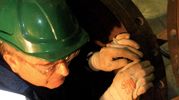 Rescue officer in safety gear climbing out of a confined space