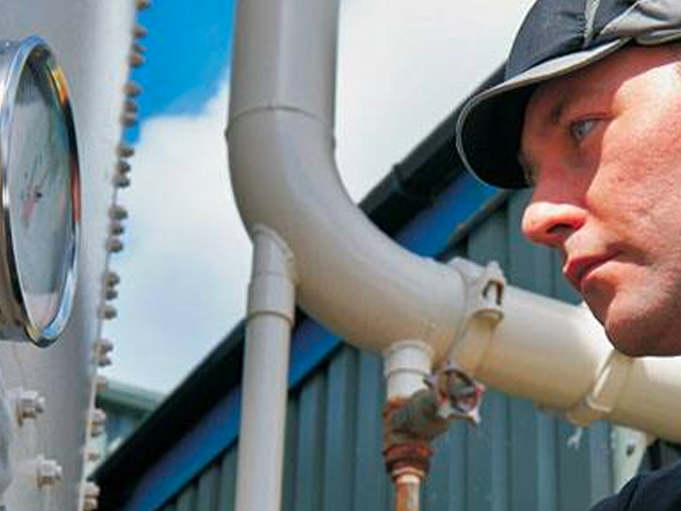 Worker closely checking readings on a meter