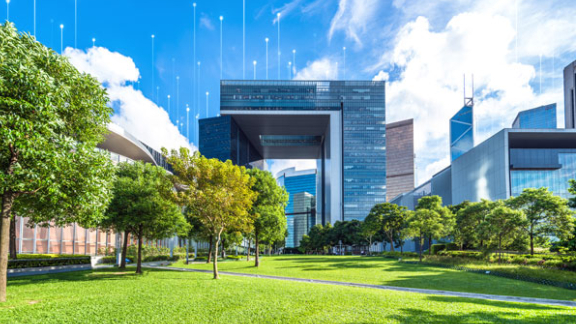 Office building in a green campus on a sunny day with graphics depicting transmission nodes in the background