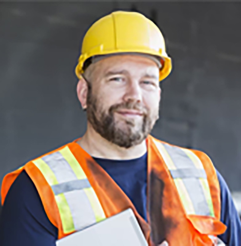 A male mechanic holding a writing pad and smiling