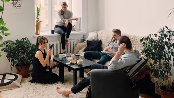 Group of people having a friendly conversation in the living area of a house