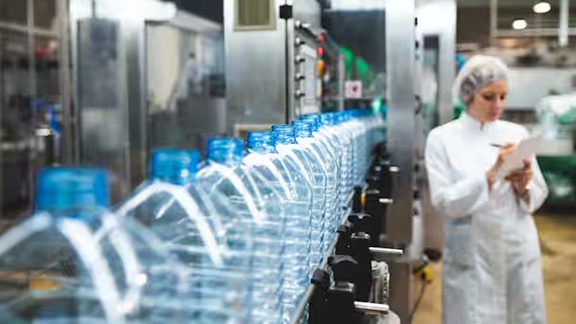 Empty plastic bottles in a sequence on a conveyor belt in a factory