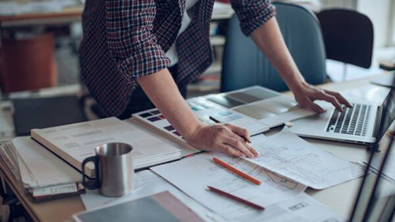Man working at a desk with documents and a laptop