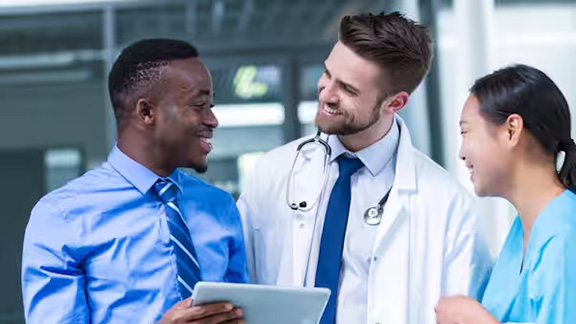Three healthcare workers in discussion in a hospital
