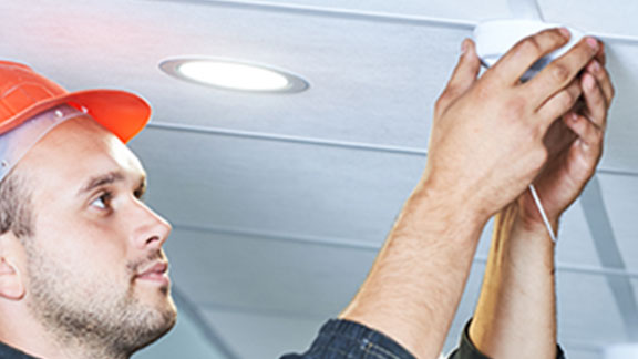 An electrician Installing spotlights on ceiling