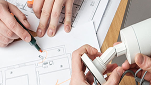 Two people discussing cctv project with blueprint on a table