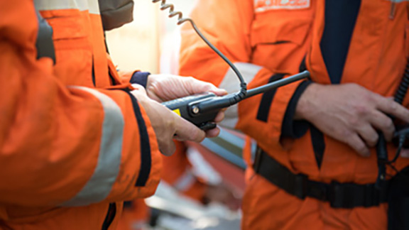 Two firefighters communicating with a walkie-talkie