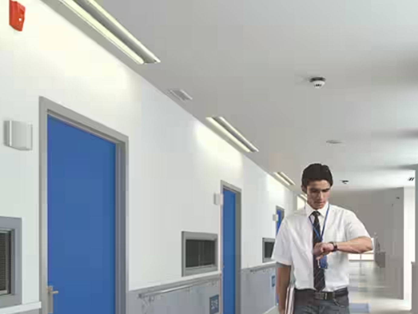 man walking in hallway looking at wrist watch