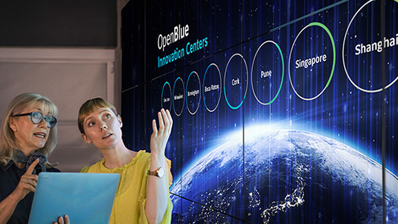 Two women discussing a presentation on OpenBlue Innovation Centers