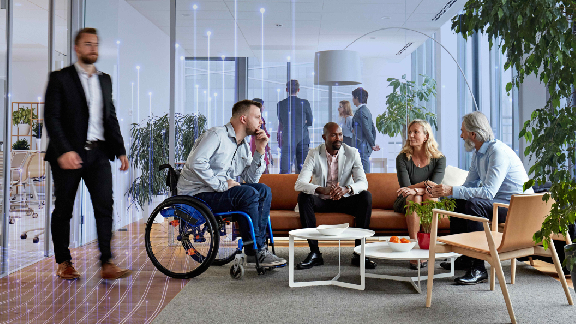 Diverse group of employees conversing in the lobby of an office