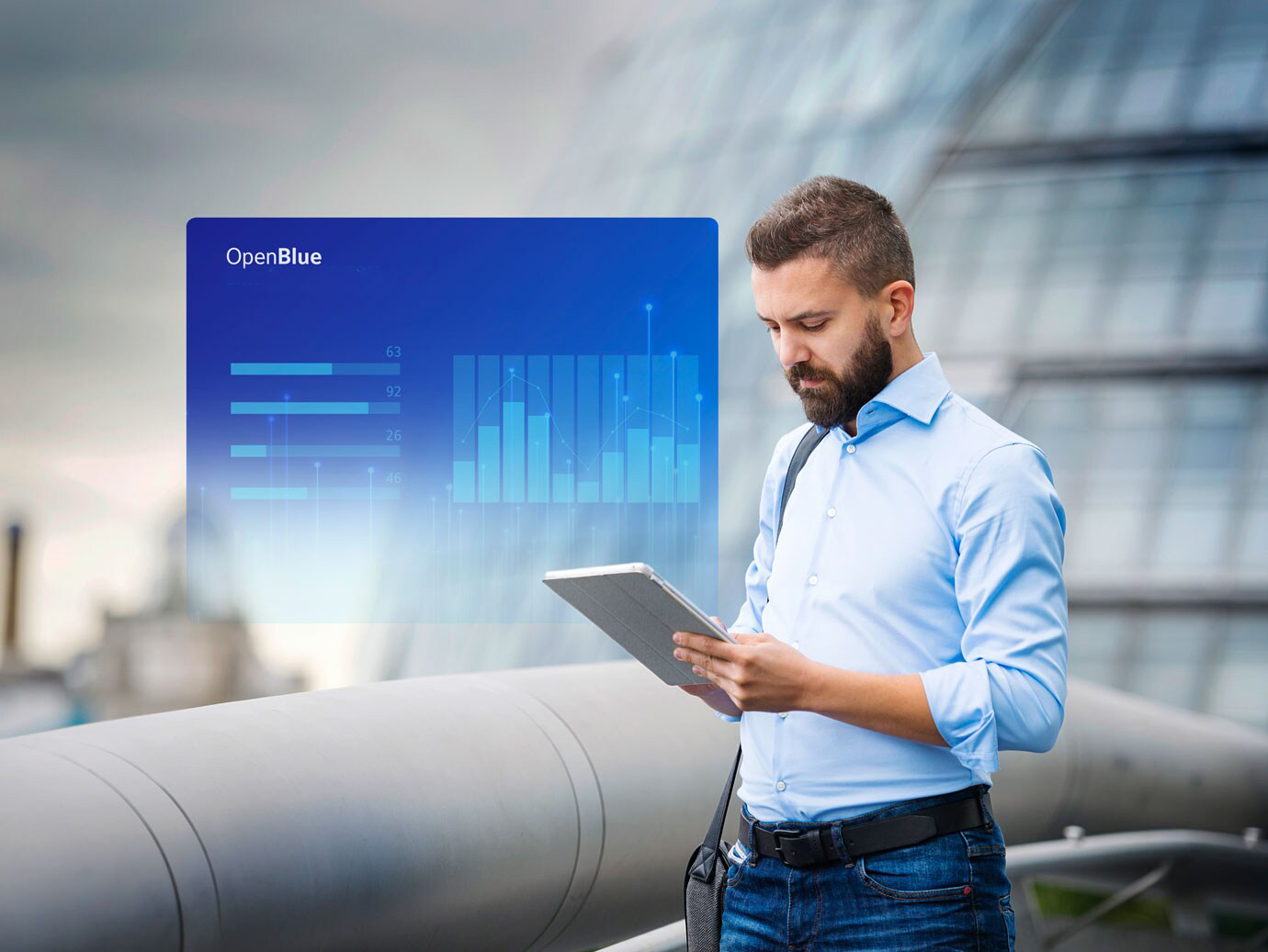 Man looking at a tablet screen with an overlaid image of OpenBlue Enterprise Manager window on the background