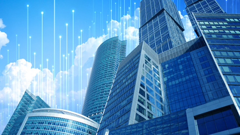 Skyscrapers with blue glass windows against a daytime sky, surrounded by OpenBlue graphics
