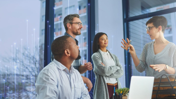 Employees conversing together near a glass window in an office, with OpenBlue graphics overlaid behind