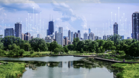 An urban skyline surrounded by greenery, with OpenBlue graphics overlaid behind